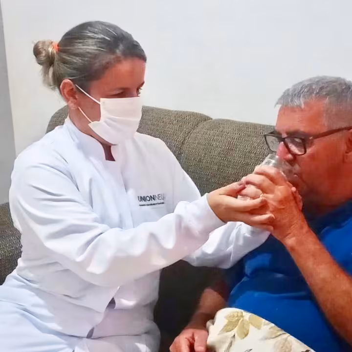Profissional dando água ao paciente