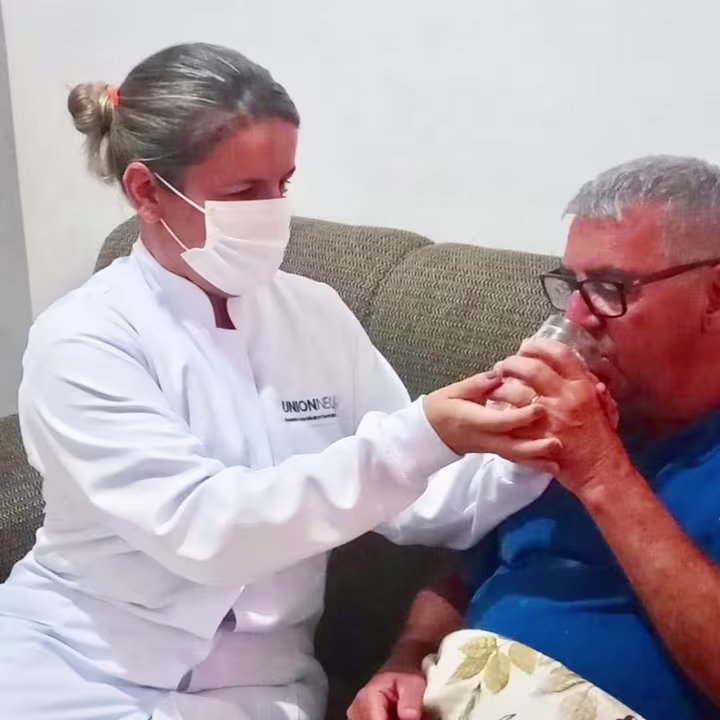 Profissional dando água ao paciente